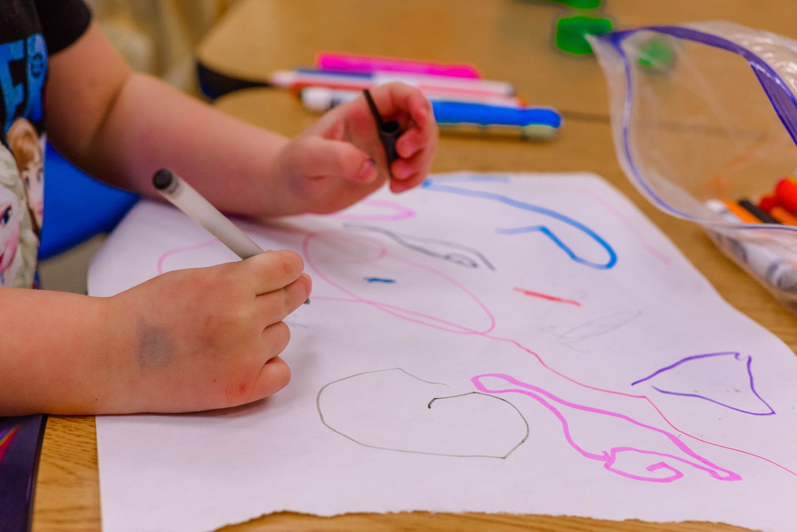 a child is drawing on a piece of paper